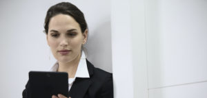 Selective focus view of smiling businesswoman using digital tablet touchscreen in modern office