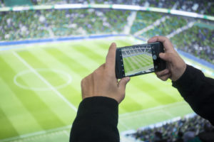 Man using a mobile phone at a stadium
