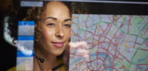 A female logistics worker  organising dispatch of freight on her interactive digital map whilst talking on her headset